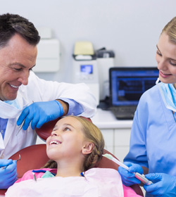 Dentist and Nurse Interacting with a Young Patient in Clinic